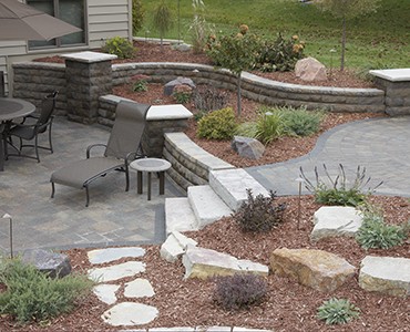 Outdoor living space featuring Belair freestanding curved retaining walls, stone stairs and paver patios