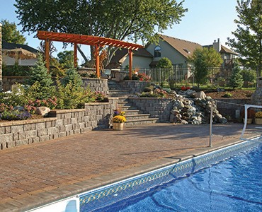 Pool area after installing paver patio, retaining walls and outdoor living space